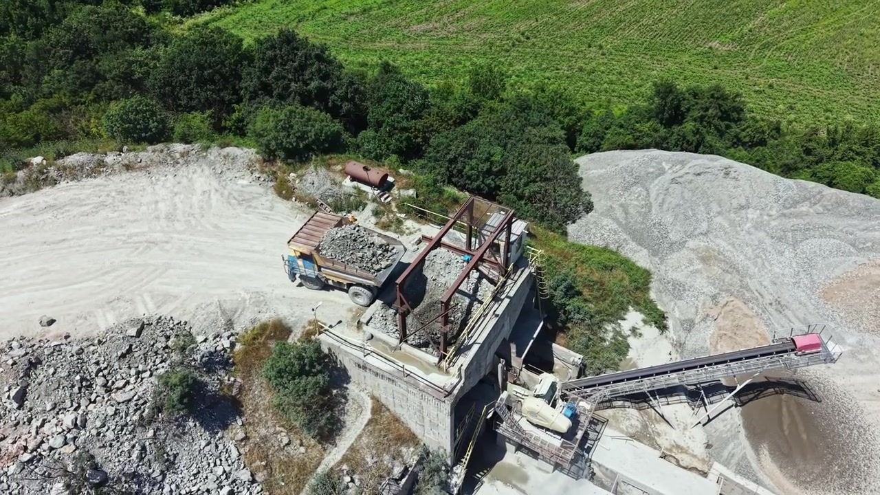Granite quarry working site with truck loading and processing materials in an open area