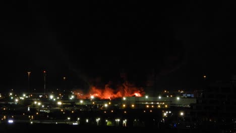 disparo estático de una planta química en llamas con humo saliendo por la noche
