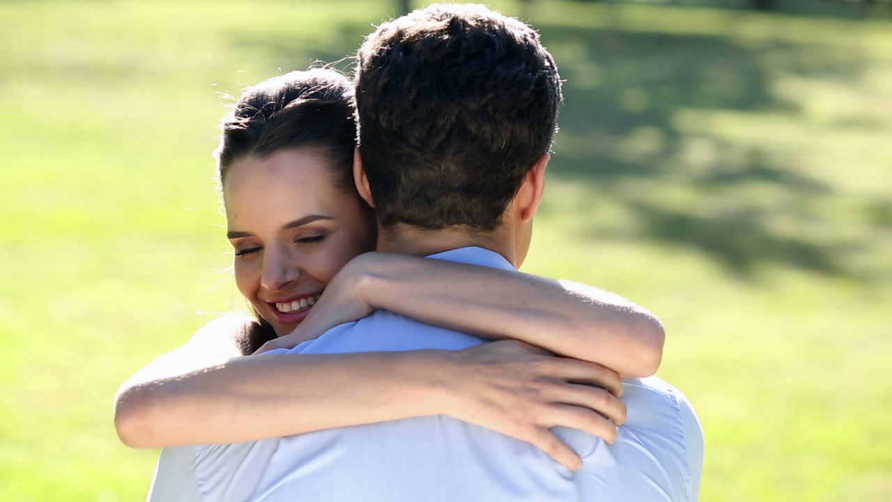 una pareja feliz abrazándose en el parque.