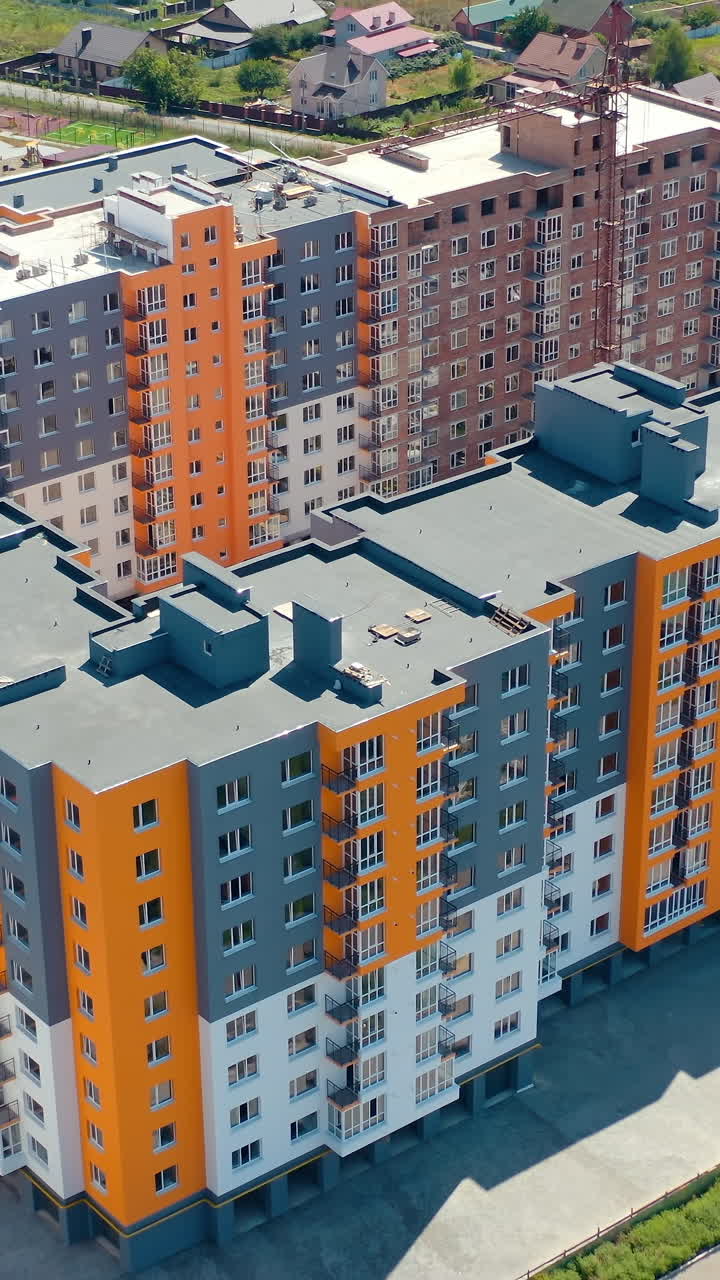 Multi-storey apartments in new area. Construction of a modern residential complex. Modern high rise architecture. Aerial view. Vertical video
