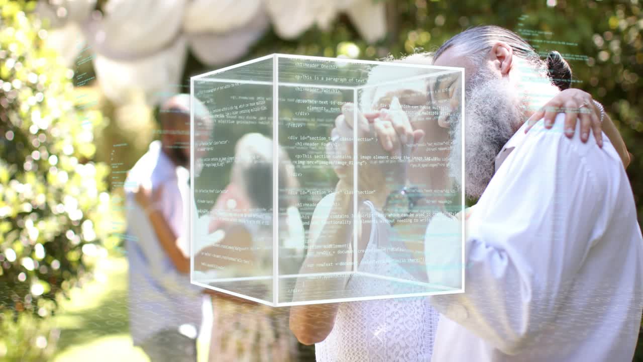 Front couple holding hands swaying celebrating, cube overlay fading in over pair, code showing tech