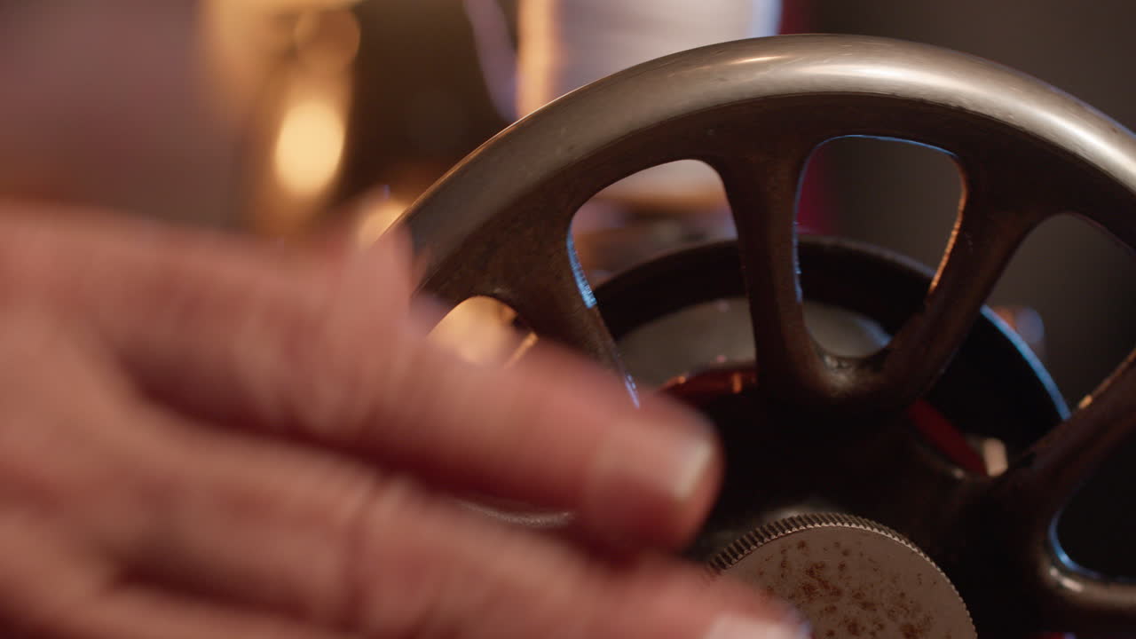Plano Detalhe de Mão Girando o Volante de uma Máquina de Costura Vintage