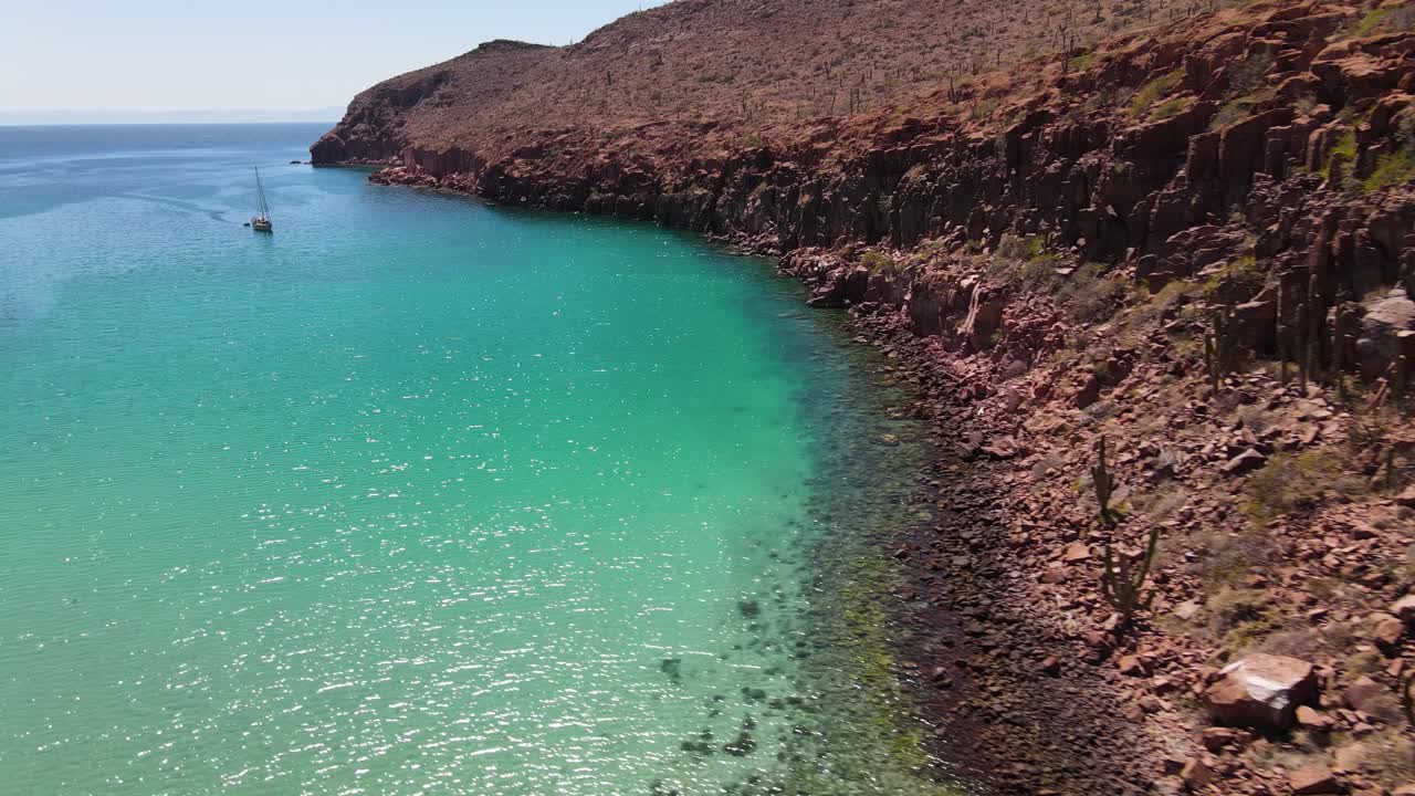antena: velero frente a la rocosa costa escarpada mexicana, bahía tropical del pacífico, espíritu santo