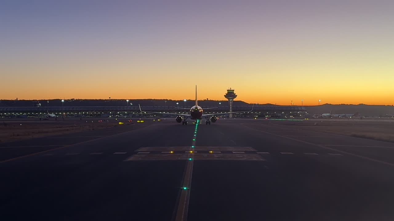 An cockpit view through the pilot’s eyes while taxiing behind a twin-engine jet through the taxiways of Madrid airport at sunrise