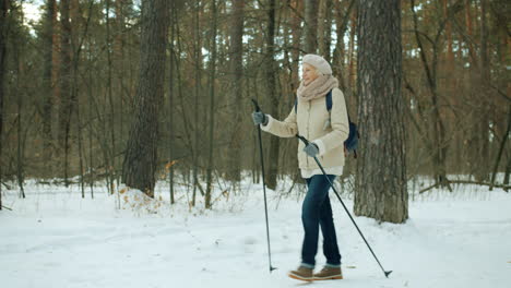 senior woman snowshoeing in a winter forest