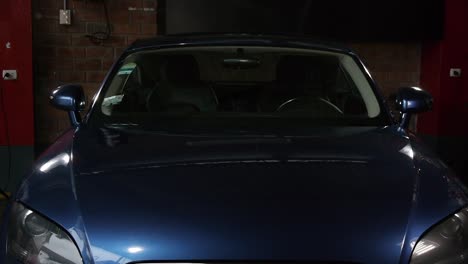 una toma frontal de un audi tt azul en un garaje