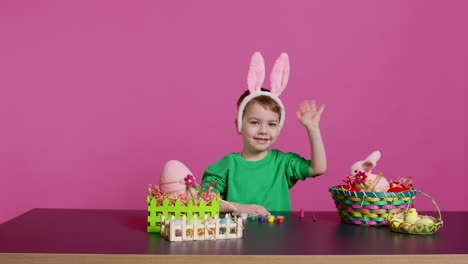 Un-Niño-Pequeño-Colocando-Orejas-De-Conejo-En-La-Cabeza-En-El-Estudio