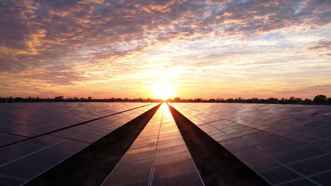Fantastisk solopgang over et stort solcellefelt: Fanger skønheden ved bæredygtig energi udnyttet under en fortryllende himmel.