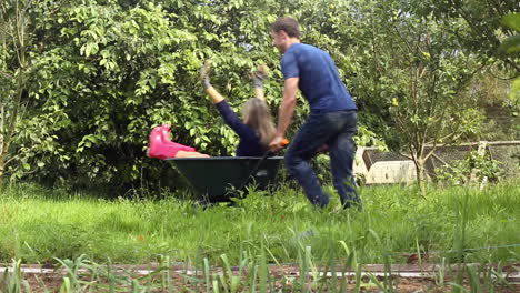 attractive young couple messing around with wheelbarrow