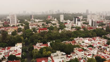 Mexico-city-suburbs-rooftops-and-covered-downtown-in-thick-fog,-aerial-view