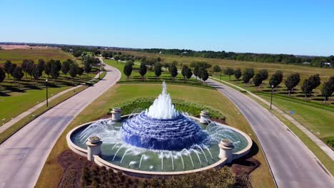 an aerial shot of a community water fountain, on a sunny day, at 60 frames