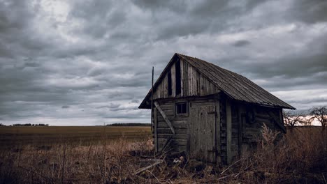 old abandoned wooden barn in the fields and cloudy sky movement time lapse video