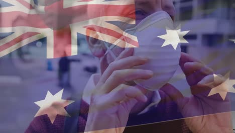 Animation-of-flag-of-australia-waving-over-caucasian-man-wearing-face-mask-in-city-street