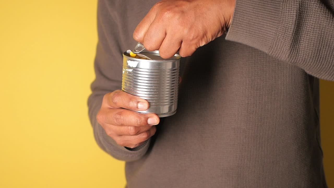 Close Up of Hands Opening a Can of Sweet Corn