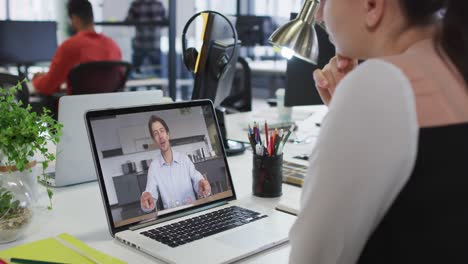 Mujer-Caucásica-Haciendo-Una-Videollamada-Con-Un-Colega-De-Oficina-En-Una-Computadora-Portátil-En-La-Oficina