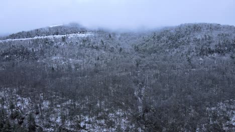 Fliegen-Durch-Wolken-über-Schneebedeckte-Berge-Und-Wälder-In-Einem-Wunderschönen-Bergtal-Im-Winter-An-Einem-Bewölkten-Tag