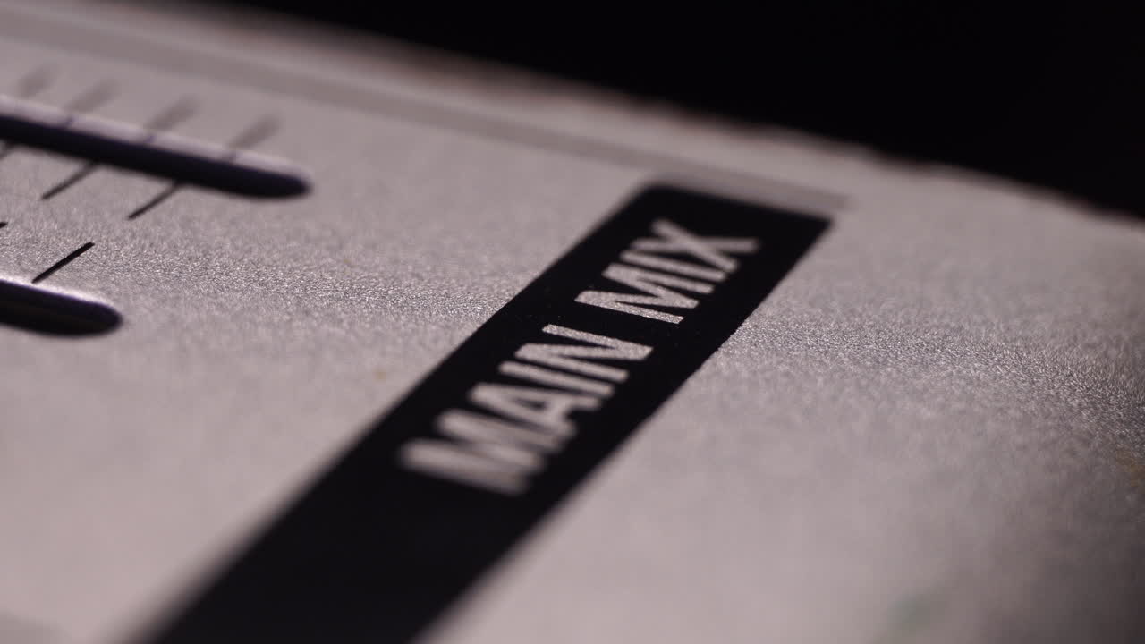 tomando los desvanecedores del maestro de mezcla principal en la consola de mezcla, silenciando la salida de sonido, macro en primer plano