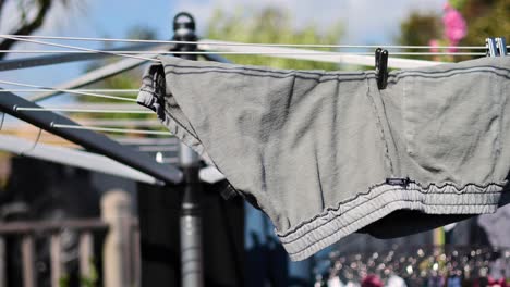 los pantalones se secan en una cuerda de ropa rotativa