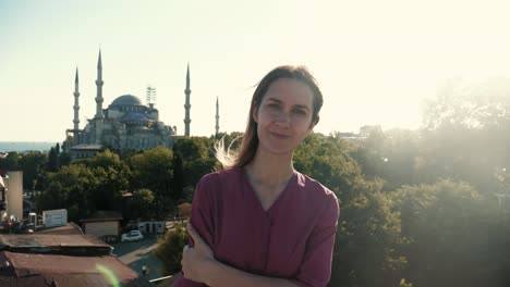 portrait of happy young tourist woman posing at beautiful view of hagia sophia, turkey on summer sunset seaside vacation