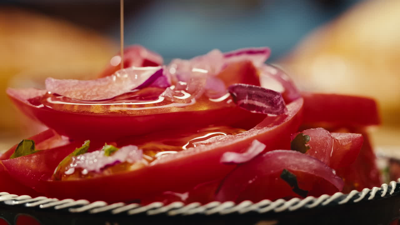primer plano de una ensalada de tomate y cebolla roja con aceite de oliva