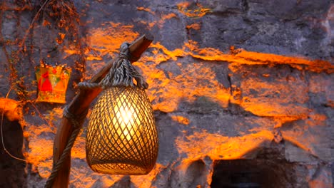 rustic wicker lantern on stone wall