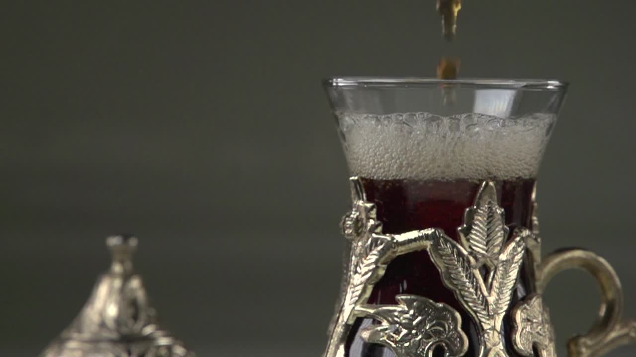 Servieren von türkischem Çay in einer traditionellen Metalltasse