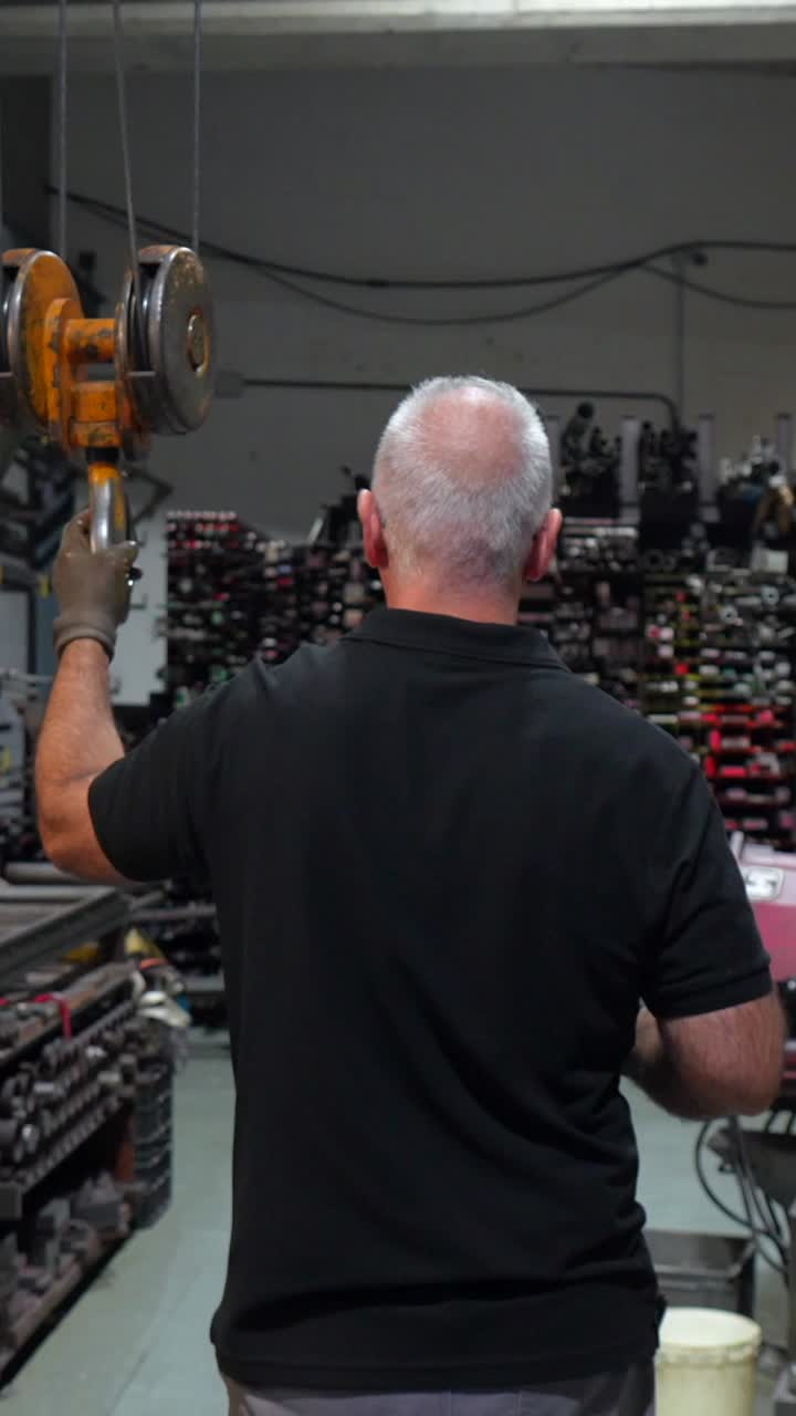 Man operating overhead crane in warehouse
