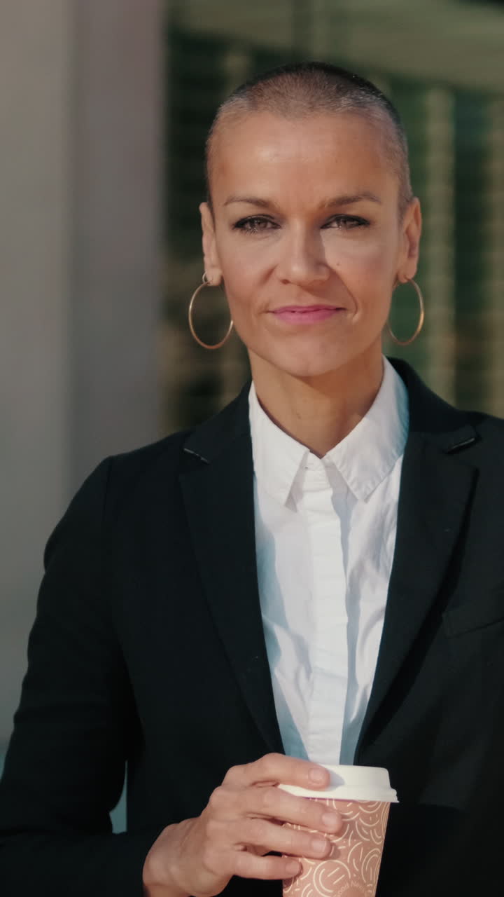 Confident Businesswoman with Shaved Head Smiling and Holding Coffee Cup