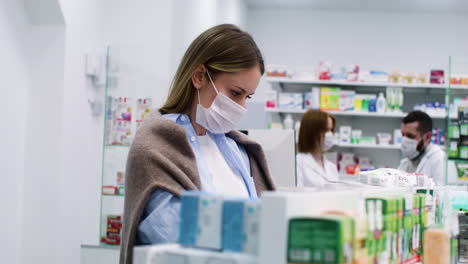 mujer con mascarilla médica en la farmacia