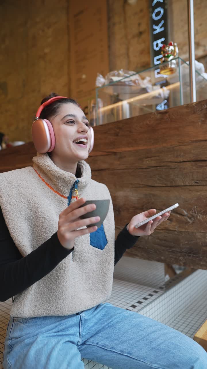Donna che si gode un caffè e la musica in una caffetteria