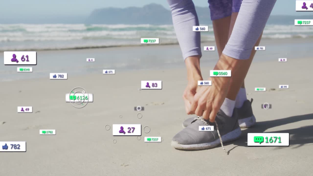 Animation of social media notifications, over woman tying shoe on beach
