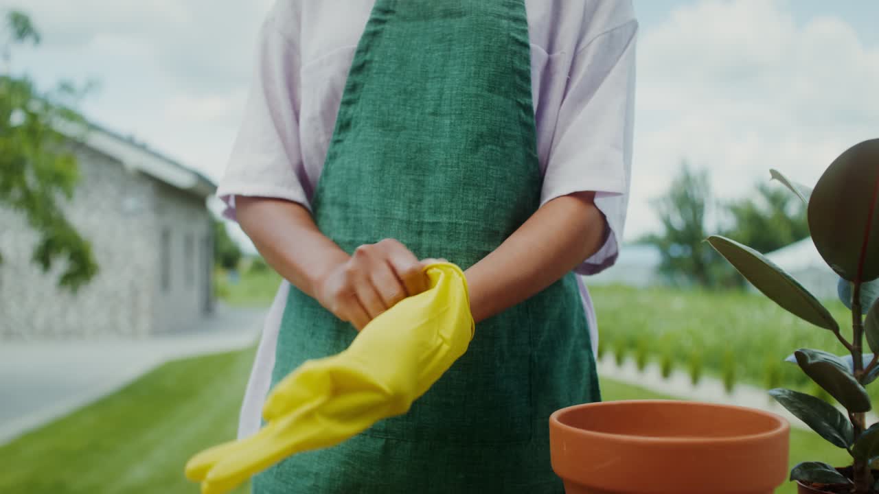 mujer poniéndose guantes de jardinería