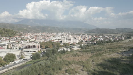 drone shot of the city of berat and its castle and fortress in albania, the city of a thousand windows on a sunny day in the valley with blue sky with white houses near the mountains log