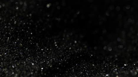 macro closeup of shiny dark black gunpowder, detail shot, background