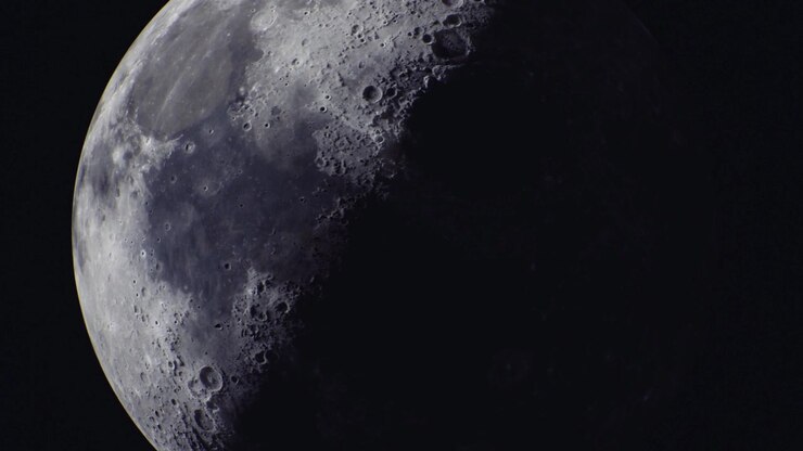 Lua crescente brilhante cintila contra o céu noturno escuro em beleza serena.