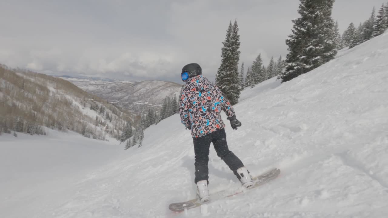 Fearless man on snowboard down steep slope, Aspen, Colorado. Winter extreme sports