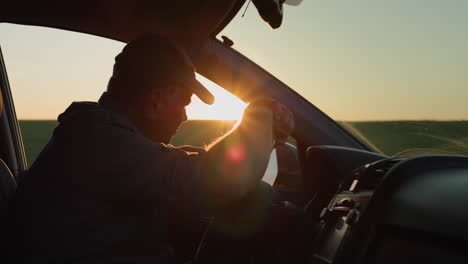 depressed man sitting behind the wheel of a car