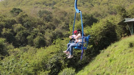 people enjoying a chairlift ride in a green landscape