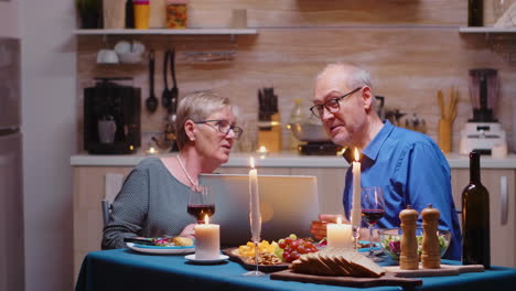 Elderly-couple-using-laptop-in-the-kitchen