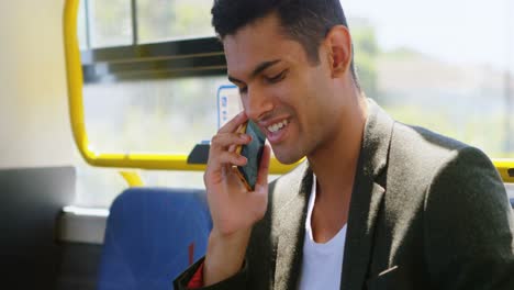 Male-commuter-talking-on-mobile-phone-while-travelling-in-bus-4k