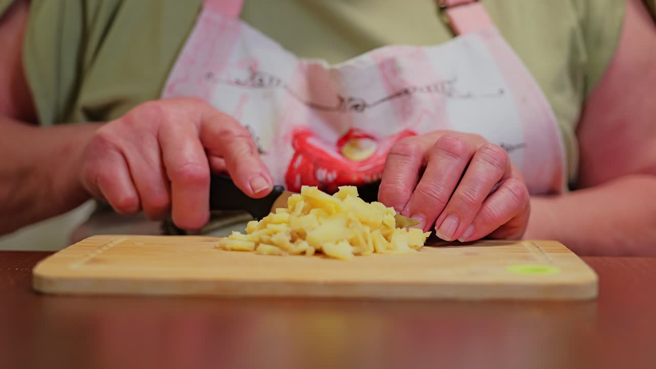 Hands cutting boiled potatoes on table creating calm homely cooking moment