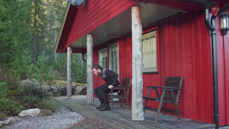 caucasian man sits on the chair in the back of red cabin