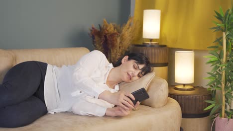 mujer durmiendo por la noche con el teléfono en la mano. adicción al teléfono.