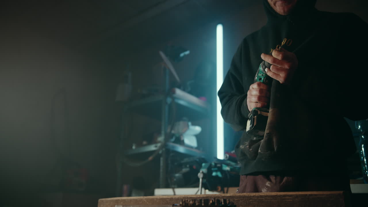 취미 목공은 상자에서 올바른 드릴 비트를 선택하고 그의 드릴에 고정합니다.