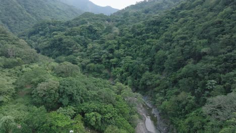 Vuelo-Lento-Sobre-Río-Bani-Rodeado-De-Una-Densa-Jungla-Montañosa-En-La-Provincia-De-Peravia,-República-Dominicana