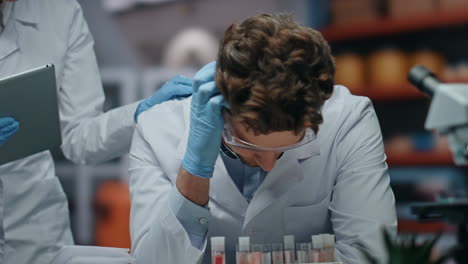 científico triste decepcionado por el fracaso de la investigación en el laboratorio con su colega en primer plano