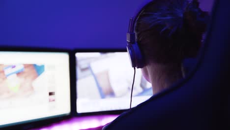 a shot of a female pro gamer from back left-side playing an online video game