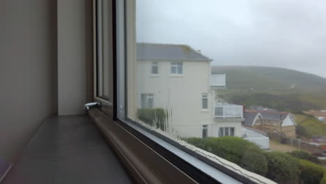 rain flowing down a window with a sea view