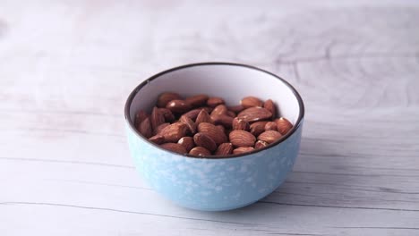 hand picking almonds from a bowl