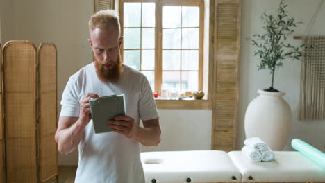 Man-holding-clipboard-and-writing